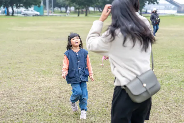 Tayvan 'ın Taipei şehrinde Datong Bölgesi' nde büyük bir parkta oynayan çocuklar ve aileler.