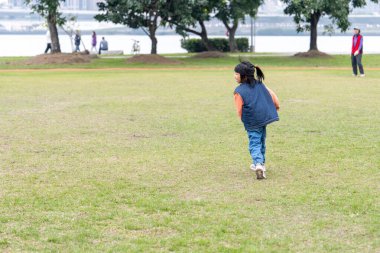 Tayvan 'ın Tayvan şehrindeki Datong Bölgesi' nde büyük bir parkta oynayan küçük bir Tayvanlı kızın çocuğu.