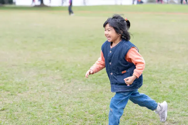 Tayvan 'ın Tayvan şehrindeki Datong Bölgesi' nde büyük bir parkta oynayan küçük bir Tayvanlı kızın çocuğu.