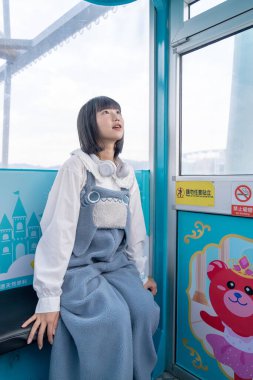 Tayvan 'ın Taipei şehrindeki Shilin semtinde bir lunaparkın dönme dolabında oynayan 20' li yaşlarında genç bir Tayvanlı kadın.