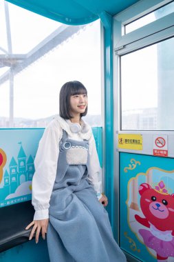 Tayvan 'ın Taipei şehrindeki Shilin semtinde bir lunaparkın dönme dolabında oynayan 20' li yaşlarında genç bir Tayvanlı kadın.