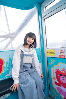 Tayvan 'ın Taipei şehrindeki Shilin semtinde bir lunaparkın dönme dolabında oynayan 20' li yaşlarında genç bir Tayvanlı kadın.