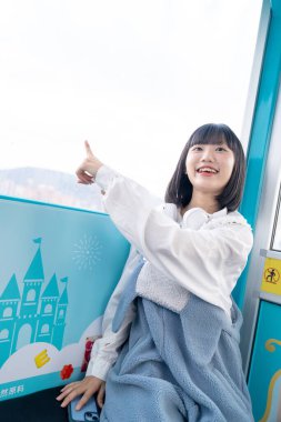 Tayvan 'ın Taipei şehrindeki Shilin semtinde bir lunaparkın dönme dolabında oynayan 20' li yaşlarında genç bir Tayvanlı kadın.