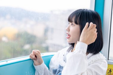 Tayvan 'ın Taipei şehrindeki Shilin semtinde bir lunaparkın dönme dolabında oynayan 20' li yaşlarında genç bir Tayvanlı kadın.