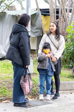 Tayvanlı bir aile soğuk kış mevsiminde Tayvan 'ın Taipei şehrindeki Datong Bölgesi' nde büyük bir parkta oynuyor.