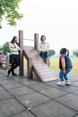 Tayvanlı bir aile soğuk kış mevsiminde Tayvan 'ın Taipei şehrindeki Datong Bölgesi' nde büyük bir parkta oynuyor.