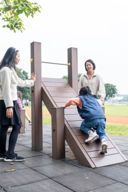 Tayvanlı bir aile soğuk kış mevsiminde Tayvan 'ın Taipei şehrindeki Datong Bölgesi' nde büyük bir parkta oynuyor.