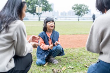 Tayvanlı bir aile soğuk kış mevsiminde Tayvan 'ın Taipei şehrindeki Datong Bölgesi' nde büyük bir parkta oynuyor.