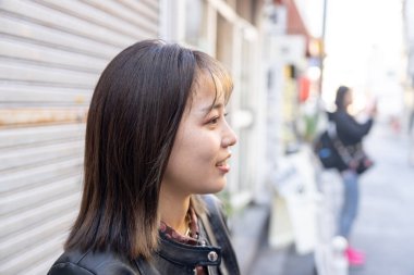 Okinawa bölgesinden 20 'li yaşlarda genç bir kadın soğuk bir kış günü Naha City, Okinawa' da Kokusai-dori Caddesi 'nde yürüyor.