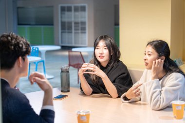 Tayvanlı ve Asyalı üç üniversite öğrencisi Da 'an Bölgesi, Tayvan' da bir üniversite kafeteryasında konuşuyorlar.