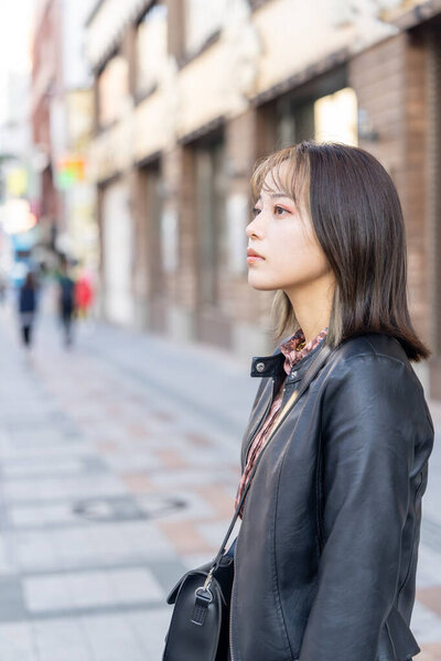 Молодая женщина из префектуры Окинава, около 20 лет, ходит по улице Кокусай-дори в городе Наха, префектура Окинава, холодной зимой