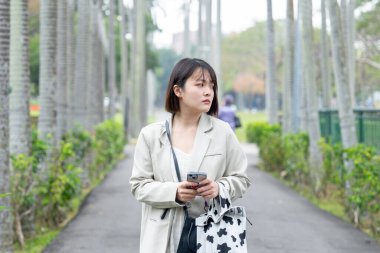 Tayvan 'ın Taipei şehrinde, Shilin Bölgesi' nde büyük bir parkta yürüyüş yapan 20 'li yaşlarında genç bir Tayvanlı kadın.