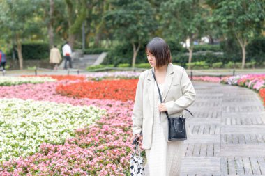 Tayvan 'ın Taipei şehrinde, Shilin Bölgesi' nde büyük bir parkta yürüyüş yapan 20 'li yaşlarında genç bir Tayvanlı kadın.