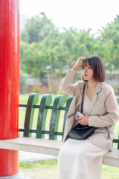 Молодая тайваньская женщина в возрасте 20 лет прогуливается в большом парке в районе Шилинь, Тайбэй, Тайвань