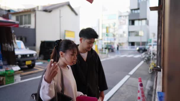 Ein Junges Japanisches Paar Seinen Zwanzigern Beim Takoyaki Essen Der — Stockvideo