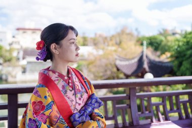 Okinawa 'nın Naha şehrindeki bir Çin bahçesinde Ryuso giyen 20' li yaşlarda genç bir Japon kadın.