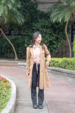 Tayvanlı 20 'li yaşlarda bir kadın Songshan Wenso Park, Xinyi Bölgesi, Taipei Şehri, Tayvan' da bir parkta vakit geçiriyor.