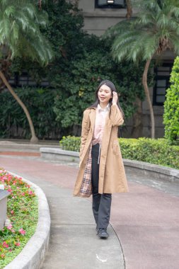 Tayvanlı 20 'li yaşlarda bir kadın Songshan Wenso Park, Xinyi Bölgesi, Taipei Şehri, Tayvan' da bir parkta vakit geçiriyor.