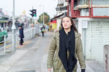 Hong Kong 'un Yeni Bölgeleri' nde yirmili yaşlarda bir kadın yürüyor.