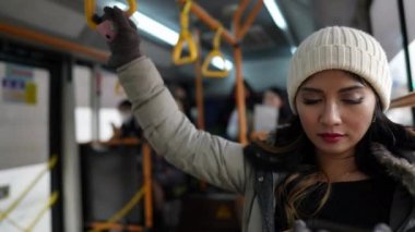 Güney Kore 'nin Seul kentsel bölgesinde, soğuk bir kış gününde otobüsle gezen 20' li yaşlarda Filipinli bir kadının yavaş çekim videosu.
