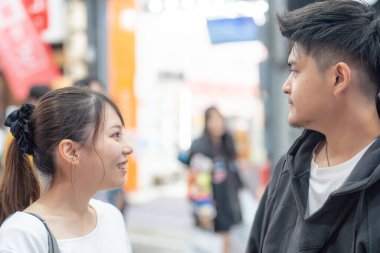 20 'li yaşlarda Japon bir çift Nagoya City, Aichi' de kızarmış sokak yemeği yiyor. 