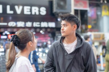 20 'li yaşlarda Japon bir çift Nagoya City, Aichi' de kızarmış sokak yemeği yiyor. 