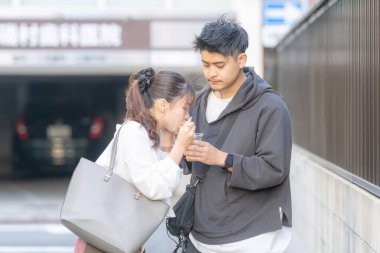 20 'li yaşlarda Japon bir çift Nagoya City, Aichi' de kızarmış sokak yemeği yiyor. 