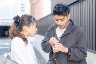 20 'li yaşlarda Japon bir çift Nagoya City, Aichi' de kızarmış sokak yemeği yiyor. 