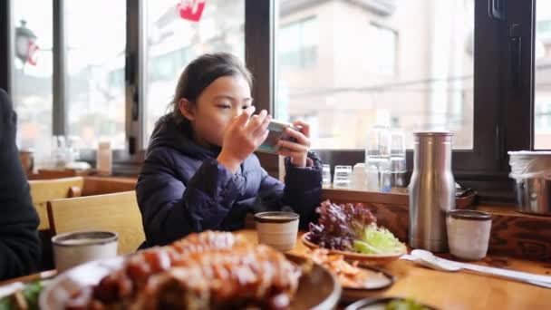 Głodna Koreańska Nastolatka Operująca Smartfonem Czekająca Jedzenie Restauracji Seulu Korea — Wideo stockowe