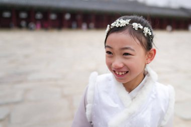 Güney Kore, Seul 'deki Gyeongbokgung Sarayı' nda geleneksel bir kostüm giymiş Koreli bir kız kameraya gülüyor.