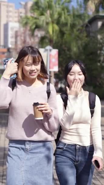 Pionowy Filmik Dwoma Młodymi Tajwańskimi Studentkami Chodzącymi Szczęśliwie Podczas Rozmowy — Wideo stockowe