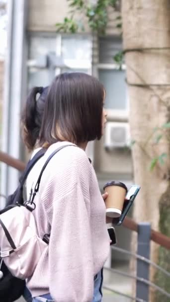 台湾の台北の大学キャンパスで話しながら 台湾の若い女性大学生2人の垂直なスローモーションビデオ — ストック動画