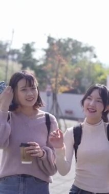 Taipei, Tayvan 'da bir üniversite kampüsünde konuşan iki genç Tayvanlı kız öğrencinin dikey videosu. 