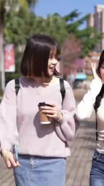 Taipei, Tayvan 'da bir üniversite kampüsünde konuşan iki genç Tayvanlı kız öğrencinin dikey videosu. 