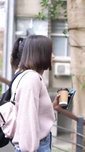 台湾の台北にある大学キャンパスで話しながら 台湾の若い女性大学生2人の垂直ビデオ — ストック動画