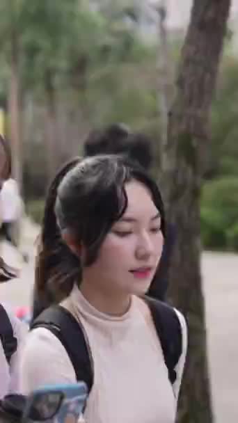 台湾の台北にある大学キャンパスで話しながら 台湾の若い女性大学生2人の垂直ビデオ — ストック動画