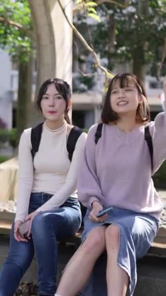 台湾の台北にある大学キャンパスで喜んで話している2人の台湾の女子大学生の垂直ビデオ — ストック動画