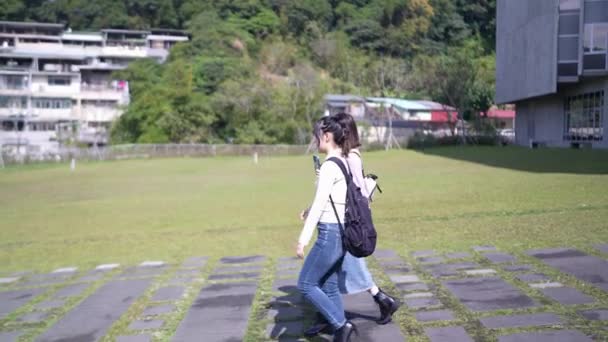 台湾台北市的一个大学校园里 两名20多岁的台湾女大学生一边走路一边聊天的慢镜头 — 图库视频影像