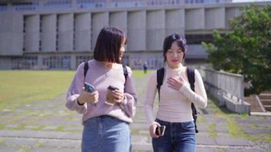 Tayvan 'ın Taipei şehrinde bir üniversite kampüsünde konuşan 20' li yaşlarda iki Tayvanlı kız öğrencinin yavaş çekim videosu.