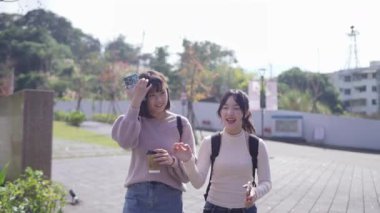 Tayvan 'ın Taipei şehrinde bir üniversite kampüsünde konuşan 20' li yaşlarda iki Tayvanlı kız öğrencinin yavaş çekim videosu.