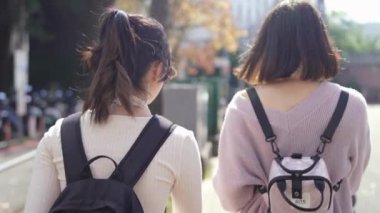 Tayvan 'ın Taipei şehrinde bir üniversite kampüsünde konuşan 20' li yaşlarda iki Tayvanlı kız öğrencinin yavaş çekim videosu.