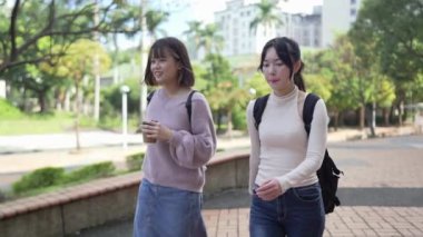 Tayvan 'ın Taipei şehrinde bir üniversite kampüsünde konuşan 20' li yaşlarda iki Tayvanlı kız öğrencinin yavaş çekim videosu.