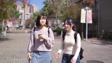 Tayvan 'ın Taipei şehrinde bir üniversite kampüsünde konuşan 20' li yaşlarda iki Tayvanlı kız öğrencinin yavaş çekim videosu.