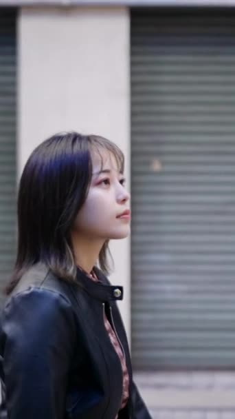 沖縄県那覇市の観光名所 国際通りの裏通りを歩いている20代の若い日本人沖縄人女性の垂直ビデオ — ストック動画