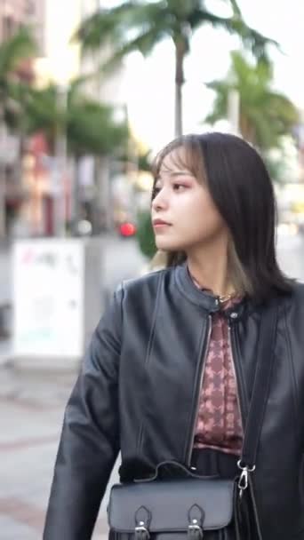 沖縄県那覇市の観光名所 国際通りを歩く20代の若い日本人沖縄人女性の垂直ビデオ — ストック動画
