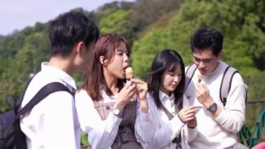 Tayvanlı dört üniversite öğrencisi, Maokong 'un doğasında, Tayvan' ın Taipei şehrinde, Wenshan Bölgesi 'nde bir turizm merkezi olan yumuşak servis dondurması yiyorlar.