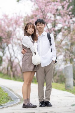 20 'li yaşlarda genç bir Tayvanlı erkek ve kadın çift, Tayvan' da bir turizm beldesi olan Maokong 'un kiraz çiçeklerinin açtığı dağlarda mutlu bir şekilde konuşurken yürüyüş yapıyorlar.. 