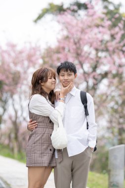 20 'li yaşlarda genç bir Tayvanlı erkek ve kadın çift, Tayvan' da bir turizm beldesi olan Maokong 'un kiraz çiçeklerinin açtığı dağlarda mutlu bir şekilde konuşurken yürüyüş yapıyorlar.. 