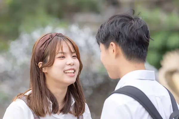 A young Taiwanese male and female couple in their 20s stare at each other in the Maokong, a tourist destination in Taiwan.