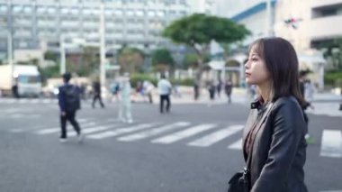 Okinawa bölgesinden genç bir Japon kadın 20 'li yaşlarda Naha City, Okinawa' da Kokusai Caddesi 'nde tek başına yürüyor.